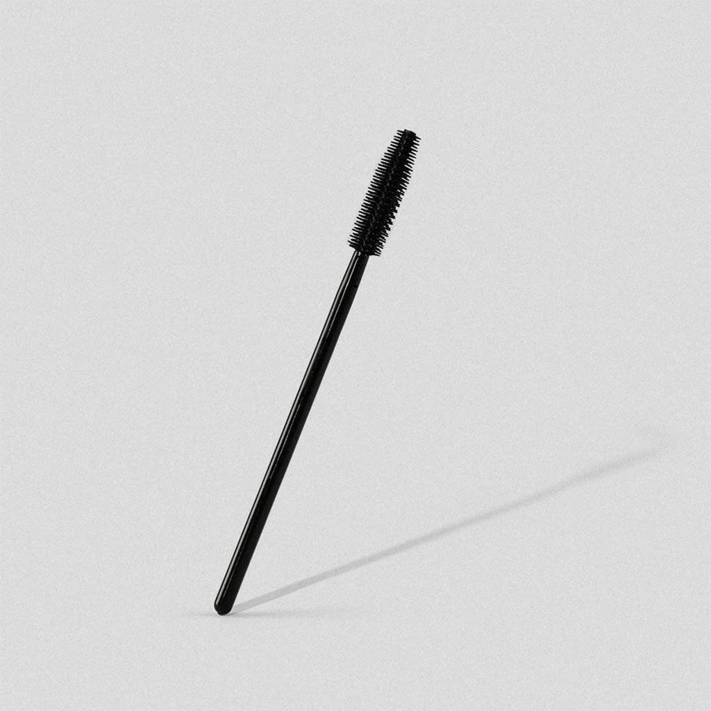 Multiple black mascara brushes on a white background